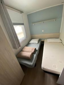 纳博讷普拉日Mobil home - Clim, TV - Camping Falaise Narbonne Plage 4 étoiles - 010的小房间设有两张床和窗户