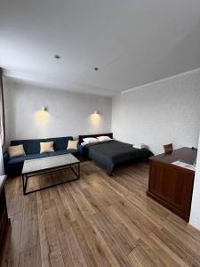 克洛佩夫尼茨基Готель Elisavetgrad的一间卧室配有一张床、一张沙发和一张桌子
