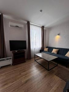 克洛佩夫尼茨基Готель Elisavetgrad的客厅配有蓝色的沙发和电视
