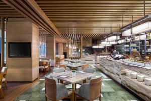 深圳金茂深圳 JW 万豪酒店的一间带桌椅的餐厅和一间酒吧