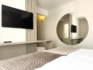 伊佐拉海湾酒店的一间带大镜子和床的卧室