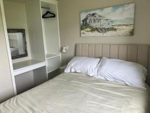 ScratbyLA BELLA CHALETS 2 - 155 Sunbeach Holiday Village Scratby的一间卧室配有一张床,享有海滩美景