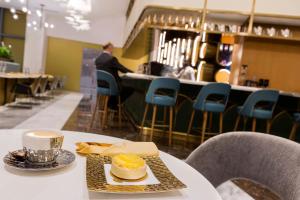 多哈Velero Hotel Doha Lusail的餐桌,饭盘,咖啡