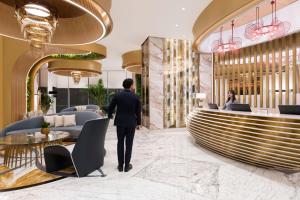 多哈Velero Hotel Doha Lusail的穿西装的人穿过大堂