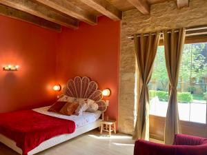 Marcillac-Saint-QuentinDomaine de Pech Mortier的卧室设有红色墙壁、一张床和一个窗户