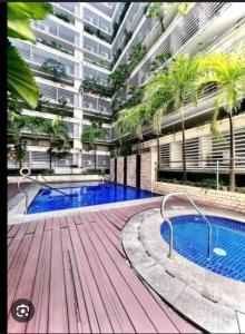 马尼拉150 Newport boulevard的一座大型公寓楼,设有游泳池和棕榈树