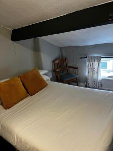 里斯Black Bull Hotel的卧室配有一张白色大床和一把椅子