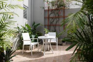 圣胡安Seaside Caribbean Comfort - Between Beach and City的庭院配有桌椅和植物