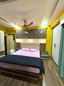 古瓦哈提Pansy B&B的一间卧室配有一张大床和吊扇