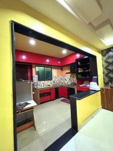 古瓦哈提Pansy B&B的一个带红色橱柜和红色柜台的大厨房