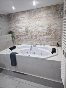 锡比乌For You Apartments Gold & Silver的浴室配有白色浴缸及石墙