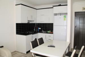 马赫姆拉阿伊冈公寓的厨房配有白色橱柜和白色的桌椅