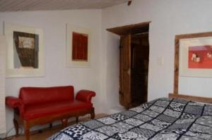 迈恩费尔德Das spezielle Ferienhaus Heidi - b48536的一间卧室配有一张床和一张红色椅子