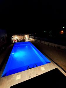 莫斯塔尔Apartments Calimero的夜间大型蓝色游泳池