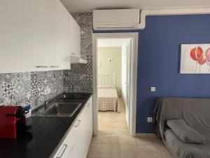 卡拉恩·布拉內斯Mitjaneta Apartamento con piscina的厨房设有水槽和蓝色的墙壁