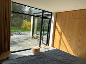 NærumModern bungalow in forest area的一间卧室设有大玻璃门,享有庭院的景色