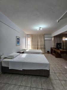 巴西利亚IKA Apart Hotel的酒店客房设有两张床和电视。