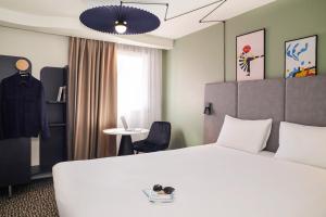 特里尼亚克宜必思圣纳扎尔特里纳克酒店的酒店客房配有白色的床和桌子