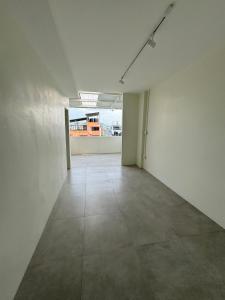 曼谷Line Bangkok Hostel的一间空房间,拥有白色的墙壁和瓷砖地板