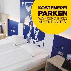帕德博恩IBB Hotel Paderborn的一间卧室设有两张床和黄色标志