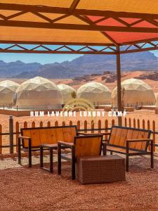 瓦迪拉姆Rum Laverne Luxury Camp的一群长椅坐在沙漠的伞下