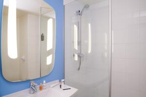 特里尼亚克宜必思圣纳扎尔特里纳克酒店的带淋浴和盥洗盆及镜子的浴室
