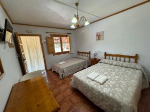 莫拉塔利亚El retiro hotel rural的一间卧室设有两张床、一张桌子和一个窗口