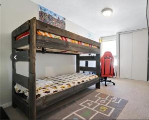 渥太华Lush Abode! Close to ottawa airport.2 spacious bedrooms的一间卧室配有双层床和红色椅子