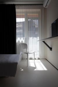 敖德萨Ultramarinn Hotel的白色的客房设有椅子和窗户。