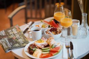 法伦克拉丽奥堡马斯塔伦连锁酒店的一张桌子,上面放着一盘食物和一杯橙汁