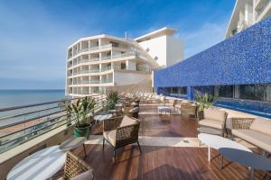 塞辛布拉Sesimbra Oceanfront Hotel的一个带桌椅的阳台和一座建筑