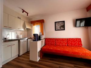 帕斯底拉卡萨弗龙特拉布兰卡酒店的一间厨房,在房间内配有红色沙发