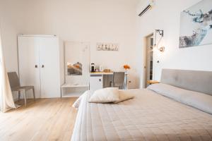托雷阿马莱Three Room - Sea View Luxury Loft的白色卧室配有床和书桌