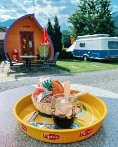 因特拉肯Camping Lazy Rancho - Eiger - Mönch - Jungfrau - Interlaken的盘子,盘子上放着一篮子的食物和一杯咖啡