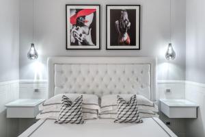 罗马罗马55号旅馆 - 西班牙广场的卧室配有一张白色床,墙上挂有三张照片
