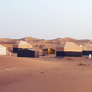 El GoueraNejma luxury camp erg chegaga的沙漠中的一群建筑物