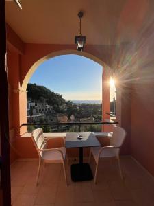 阿齐欧斯·贡多斯Aphrodite Apartments的阳台配有桌椅和窗户。