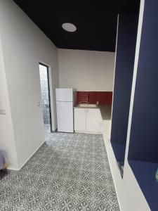 海法Romeo suite的一间空厨房,配有白色橱柜和瓷砖地板