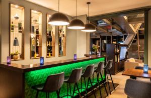 柏林柏林市南莱昂纳多精品酒店的餐厅内带桌椅的绿色酒吧