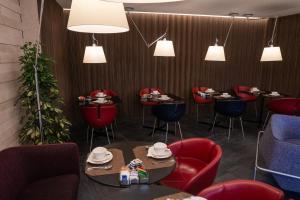 罗马斯滕达豪华套房酒店的一间设有红色椅子和桌子及灯的餐厅