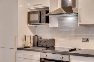 利兹DH APARTS的厨房配有白色橱柜和台面