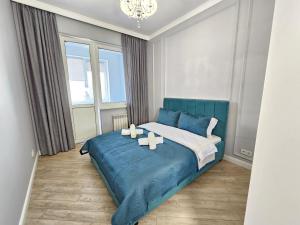 阿拉木图3 room Gagarin Park Residential Complex near MEGA Shopping Mall的一间卧室配有一张带蜡烛的蓝色床。