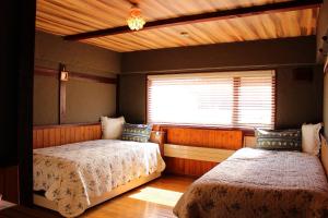 美瑛町カフェロッジ Touch Wood的一间卧室设有两张床和窗户。