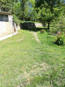 莱什Appartamento Mërqi的放着水管在草地上的院子