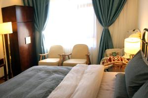 丽江La Maison du Laoshay Lijiang的酒店客房带床、椅子和窗户