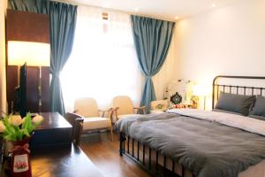 丽江La Maison du Laoshay Lijiang的卧室配有一张床和一张桌子及椅子