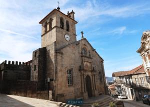 佩纳菲耶尔MyStay - Casa Matriz Séc XVI的一座古老的教堂,上面有一座塔,上面有钟