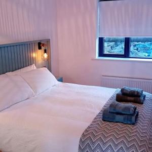 格伦科伦基尔Silver Strand Lodge的卧室配有白色的床和2条毛巾