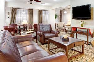 西孟菲斯华美达酒店的客厅配有皮革家具和平面电视