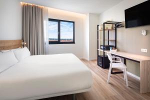 埃希哈B&B HOTEL Écija的配有一张床和一张书桌的酒店客房